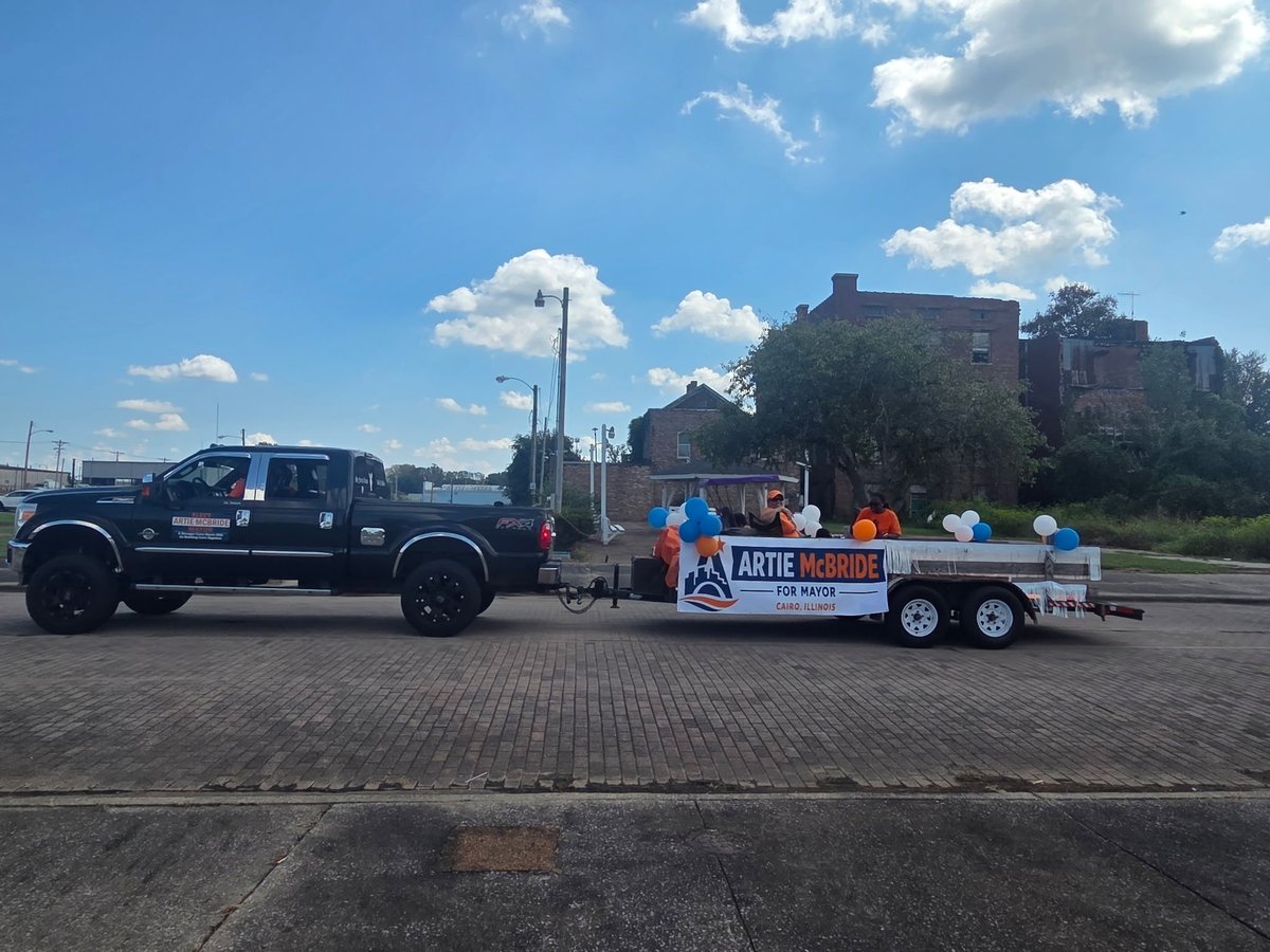 Black truck towing the Artie's Island Lemonade campaign trailer through a parking lot at the festival