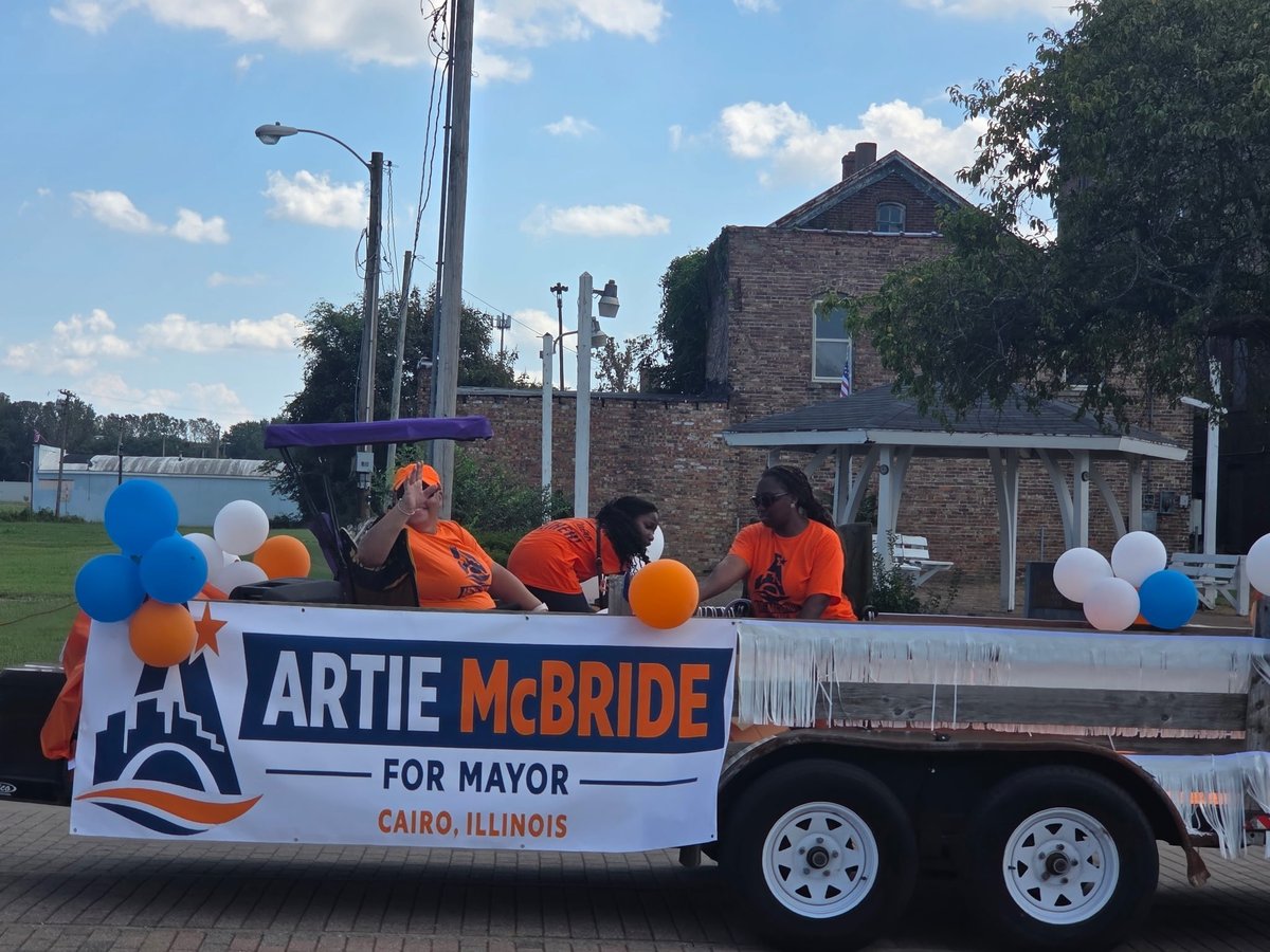 Campaign float trailer banner reading Artie McBride For Mayor, Cairo Illinois, decorated with blue, white, and orange balloons