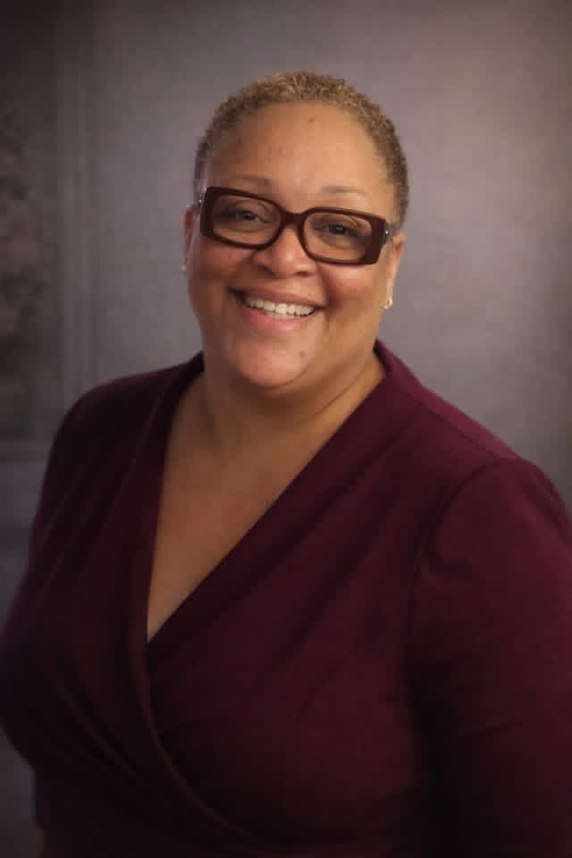 Artie McBride — professional headshot in a burgundy blazer, smiling warmly at the camera